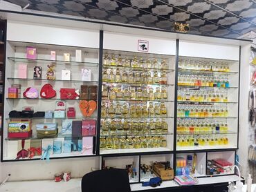 Tullantı qabları: Şəffaf şüşə rəfləri və qara haşiyəli, ağ rəngdə ticarət vitrini