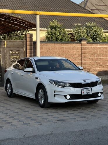 Kia: Белый седан Kia K5. Автомобиль с передним приводом оснащен передними