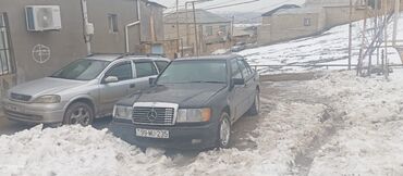 Mercedes-Benz markalı sedan avtomobili, tünd rəngdə. Dörd qapılı bu