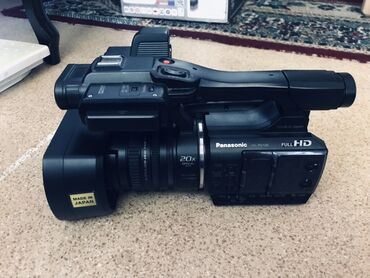 прожектор для фото: Видеокамера Panasonic черного цвета с надписью "FULL HD" и оптическим