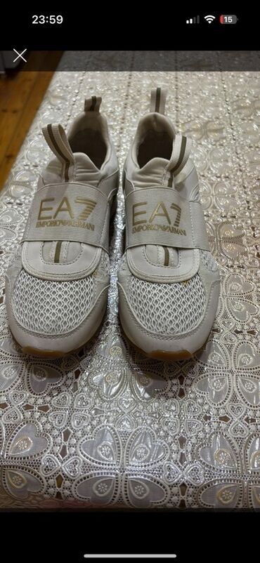 Tulumlar: Ağ rəngdə EA7 Emporio Armani idman ayaqqabısı. Ayaqqabının üst hissəsi