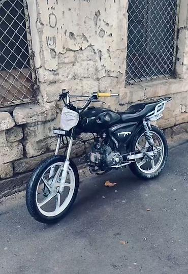 Qara rəngdə, sport üslubda yığılmış moped/motosiklet. Şəkillərdə