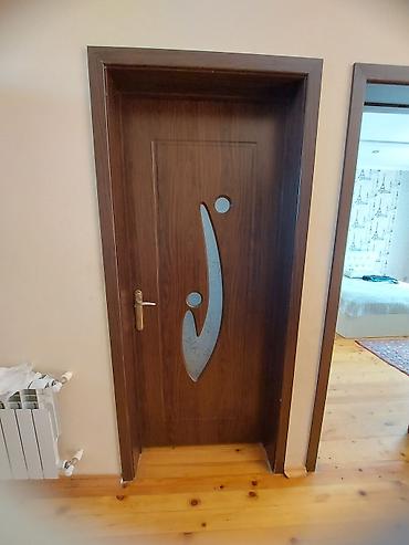 qapi taxta: Daxili otaq qapısı – taxta teksturalı, tünd qəhvəyi rəng. Mərkəzdə — 2