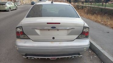 Ford: Model: Ford Focus sedan (1-ci nəsil), gümüşü rəngdə kuzov, sağ tərəfdə — 5