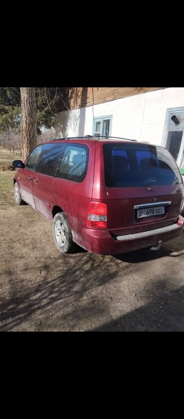 кемпинг дом на колесах: Минивэн Kia Carnival бордового цвета с тонированными задними стеклами
