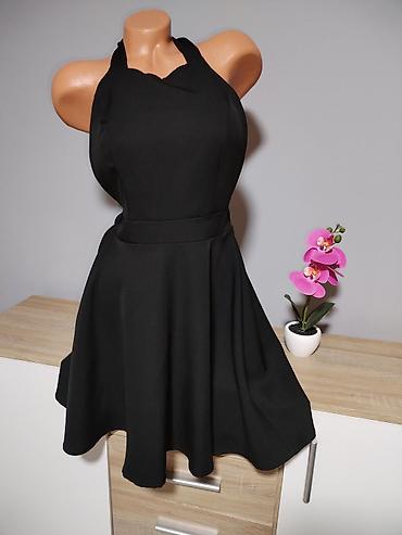 sinsej papuce: Elegantna crna kecelja/haljina sa širokom A-kroja suknjom. - Model — 1