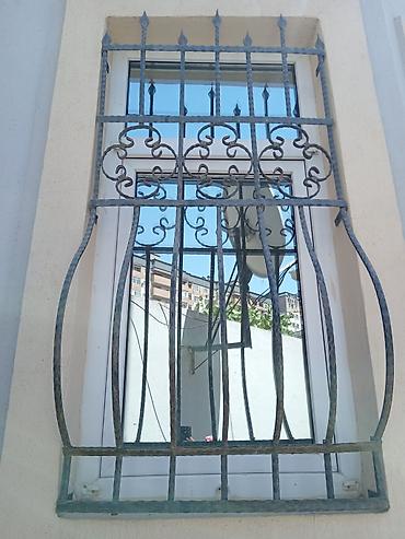 Barmaqlıqlar: Qara rəngli, dekorativ naxışlı dəmir pəncərə barmaqlıqları. Bu — 3