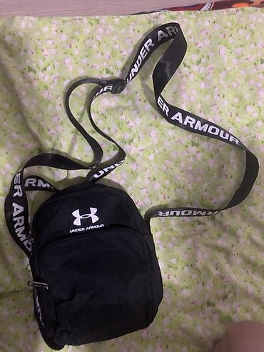 Сумка через плечо Under Armour. Компактная черная модель с длинным