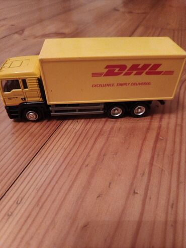 şar: DHL loqosu ilə sarı rəngli oyuncaq yük maşını. Bu oyuncaq maşının yük