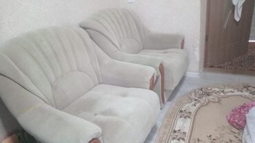 мияхкий мебел: Два мягких кресла с обивкой светлого оттенка, каждое с широкой
