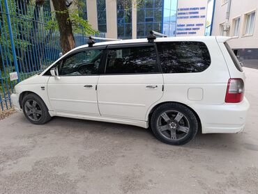 Honda: Белый минивэн Honda Odyssey с рейлингами на крыше. Автомобиль