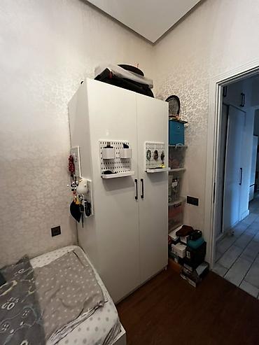 Ağ rəngli, ikiqapılı paltar şkafı. Sadə və müasir dizayna malikdir