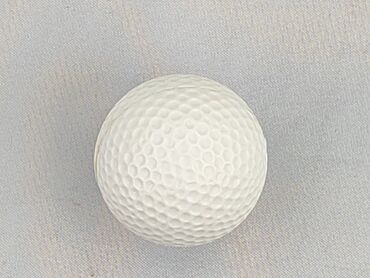 Biała piłka golfowa z charakterystycznymi wgłębieniami na całej