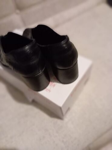 Сапоги: Qara rəngdə, deşikli dizayna malik qadın ayaqqabıları. Bu slip-on