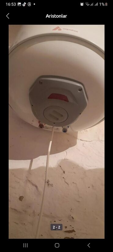 Digər su qızdırıcıları: Ağ rəngdə, silindr formalı "Aquahot" markalı su qızdırıcısı. Divara