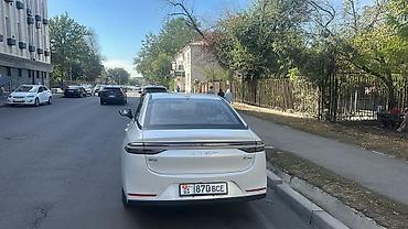 GAC: Электромобиль GAC Aion S Plus, белый седан. Ключевые особенности: - — 2