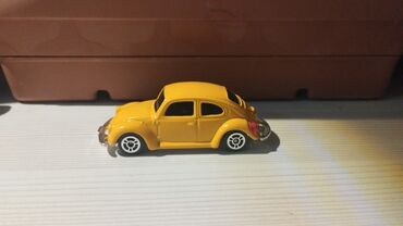 Sarı rəngdə miniatür oyuncaq avtomobil, klassik dizaynı ilə seçilir