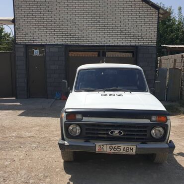 где можно купить квадроцикл: Белый внедорожник LADA Niva, оснащенный черным бампером и решеткой