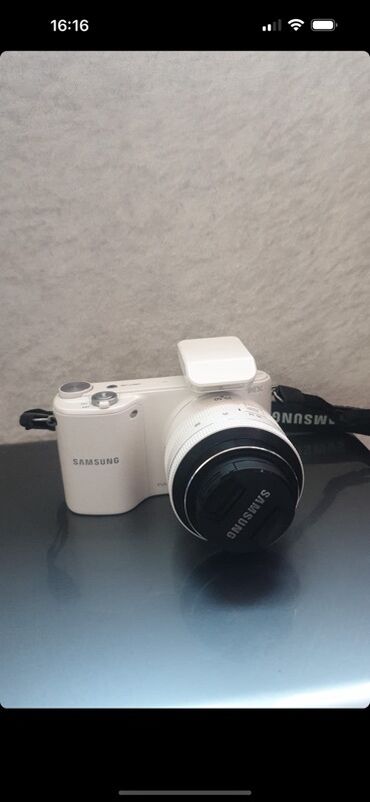 oğlan çantası: Ağ rəngdə Samsung NX 2000 seriyası rəqəmsal güzgüsüz kamera. kompakt