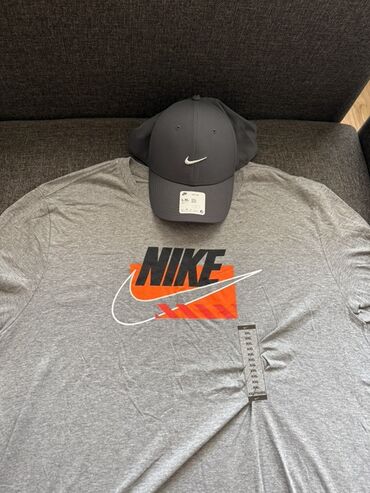 nike куртки: Комплект одежды Nike, включающий серую футболку с большим логотипом