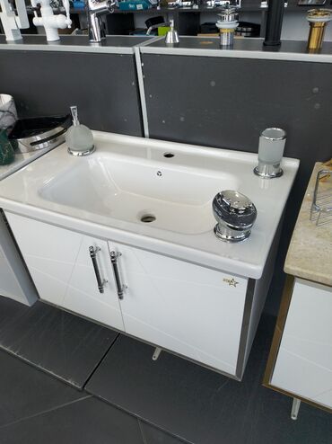 Hamam üçün aksessuarlar: Ağ rəngli, müasir dizaynlı lavabo dolabı. Dolabın ön hissəsində