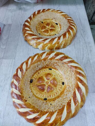 Выпечка, хлебобулочные изделия: Свежеиспеченный узбекский хлеб круглой формы, украшенный характерными — 10