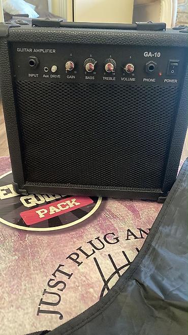 gitara tarnada: Qırmızı rəngli elektro gitara dəsti. Strat tipli korpusa malik gitara — 3