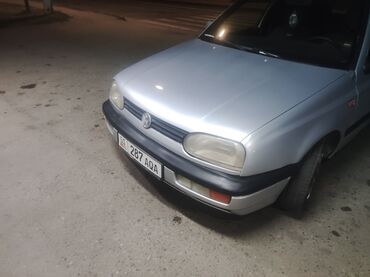 спойлер голф: Серебристый хэтчбек Volkswagen Golf III. Модель имеет округлые формы