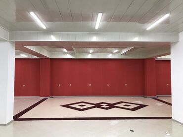 Kommersiya daşınmaz əmlakının satışı: Qırmızı divarları və dekorativ döşəməsi olan geniş otaq. Otaq