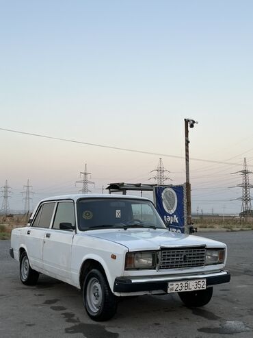 Ağ rəngli Lada 2107 sedan avtomobili. Avtomobilin dörd qapısı və geniş