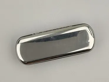 Owalne etui na okulary w kolorze srebrnym, wykonane z metalu. Wewnątrz