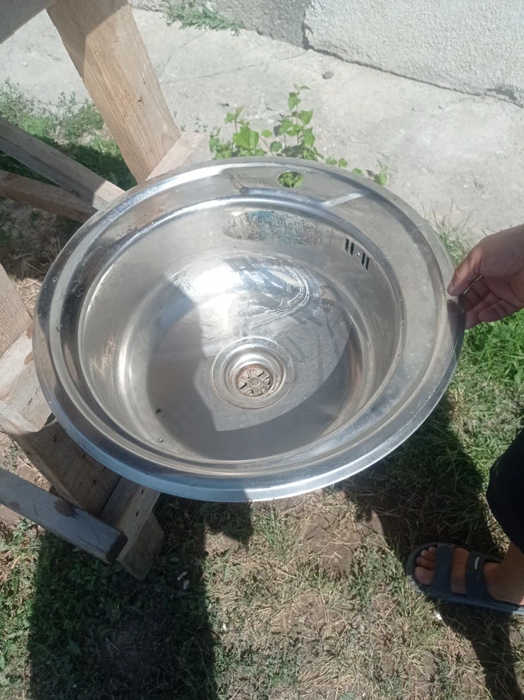 Круглая кухонная мойка из нержавеющей стали. Мойка оснащена сливным