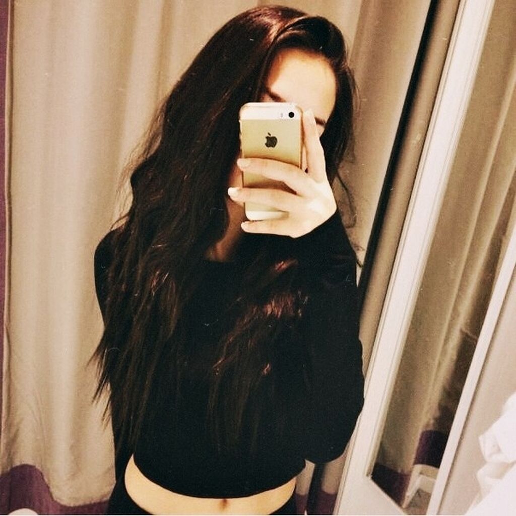 Девушка с коричневыми волосами в зеркале