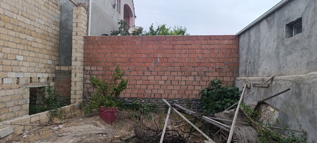 Satış üçün: hasarlı həyət və tikili karkası - Geniş darvazalı giriş