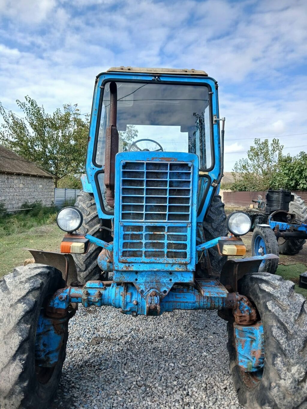 Kənd təsərrüfatı işləri üçün traktor. Mavi rəngli, qapalı kabinli