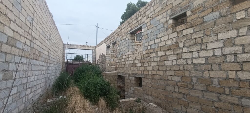 Satış üçün: hasarlı həyət və tikili karkası - Geniş darvazalı giriş