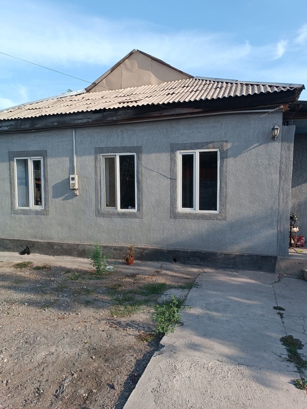 Одноэтажный дом с фасадом под штукатурку и четырьмя пластиковыми