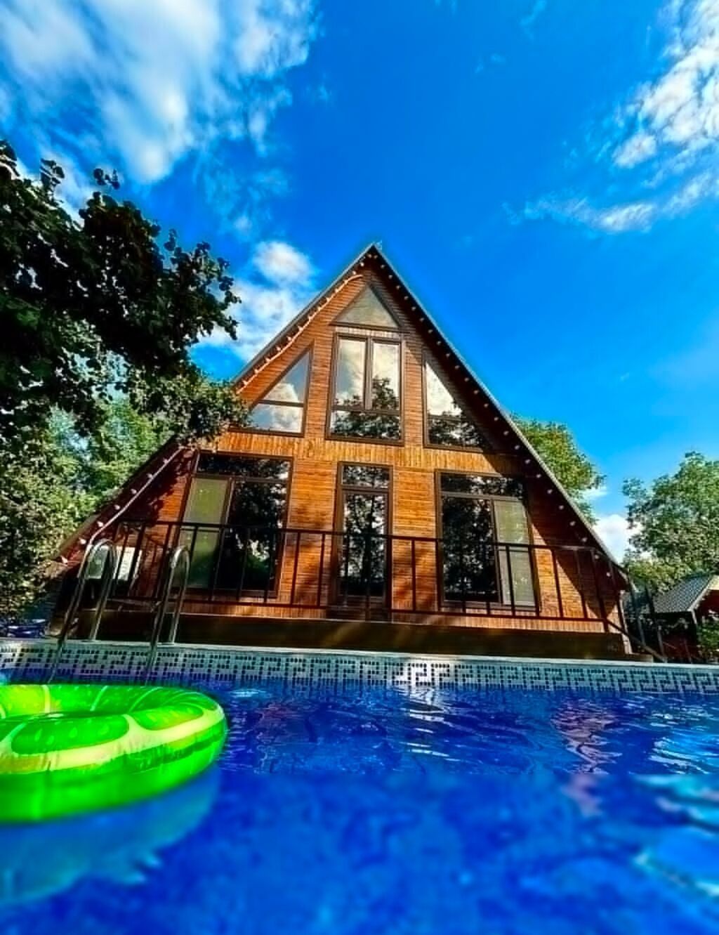 A‑frame üslubunda, taxta memarlığa malik geniş kottec. Xarici məkan